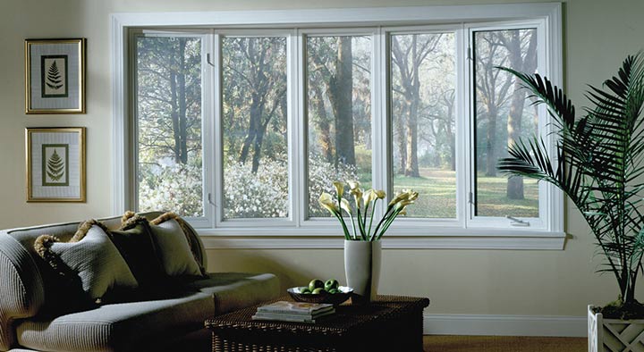 A window of a house from inside with trees on the outside