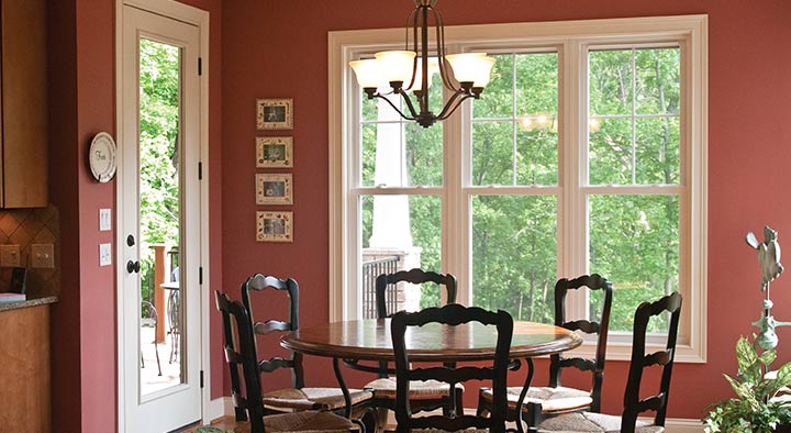 A dining room with four chairs and a table.