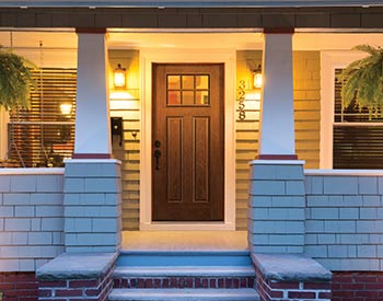 A front door of a house with lights on.