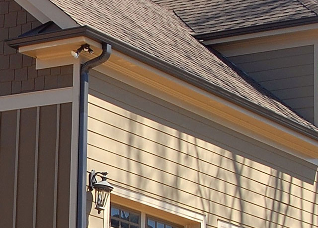 The gutter of a house with beige paint