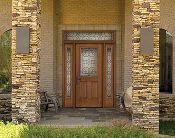 A front door with a bench and stone wall.